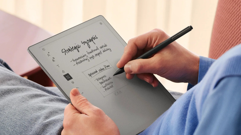 A hand using a Remarkable pen to write on a Remarkable Paper Pure tablet
