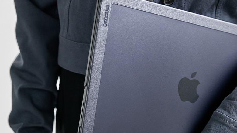Person carrying MacBook inside an Incase hardshell case