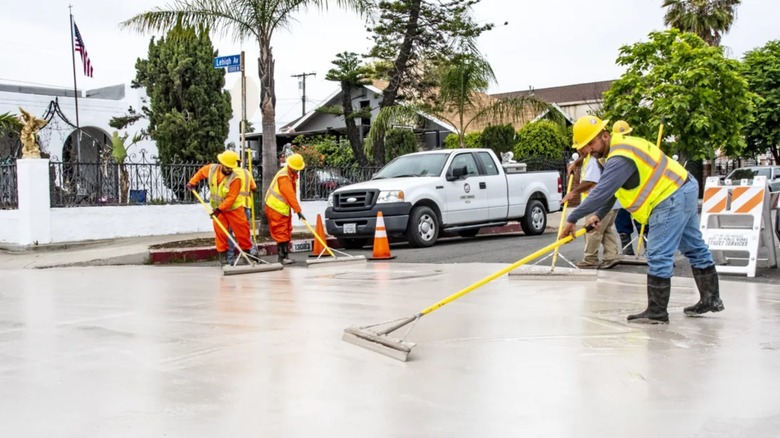 Workers painting a road in Los Angeles with heat-reflecting cool pavement