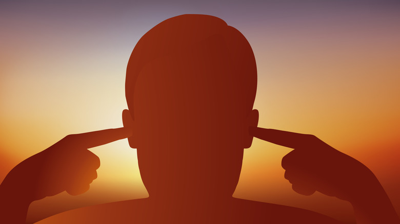 A person with their fingers in their ears.