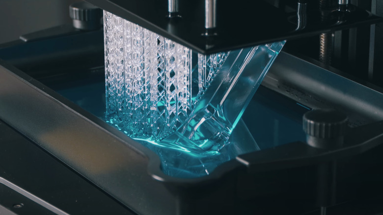 A 3D printed structure being lifted from blue resin