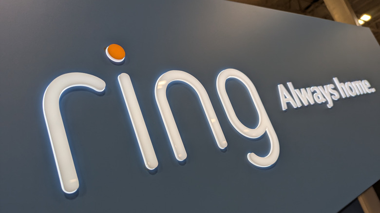 A photo of the Ring logo as its lit up with lighting against a grey background