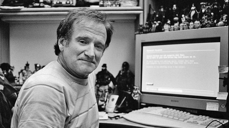 Robin Williams sitting in front of a desk with Sony GDM-FW900 monitor