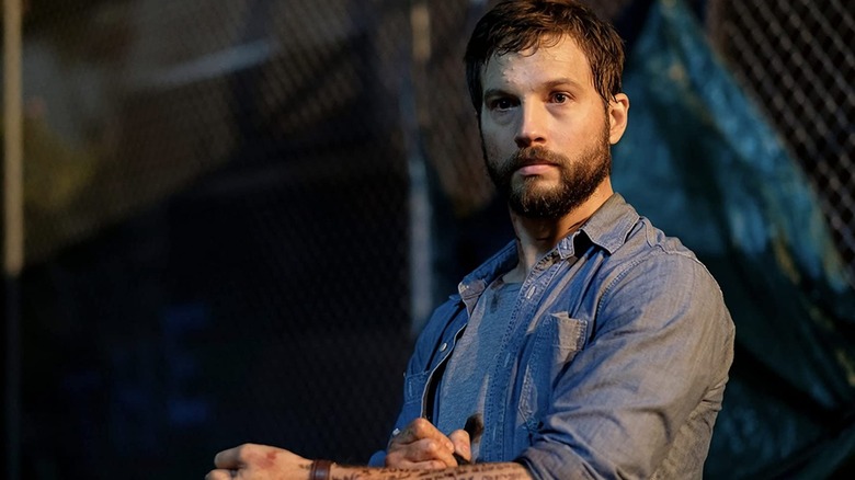 Grey Trace writing on his arm in Upgrade