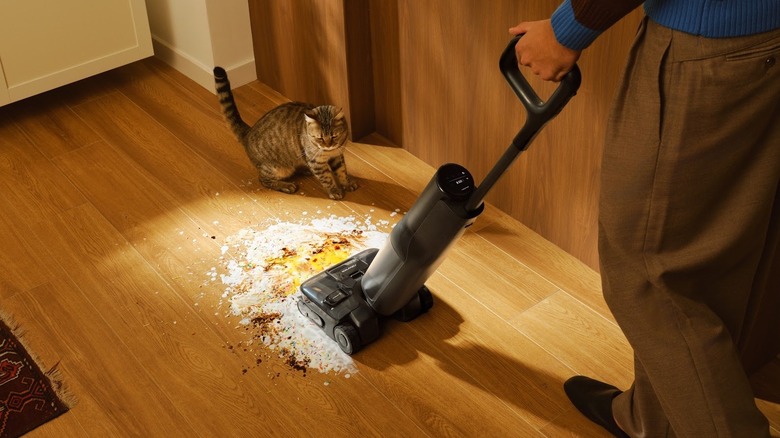 Person cleans a dirty room with Roborock F25 Ace Pro stick vacuum