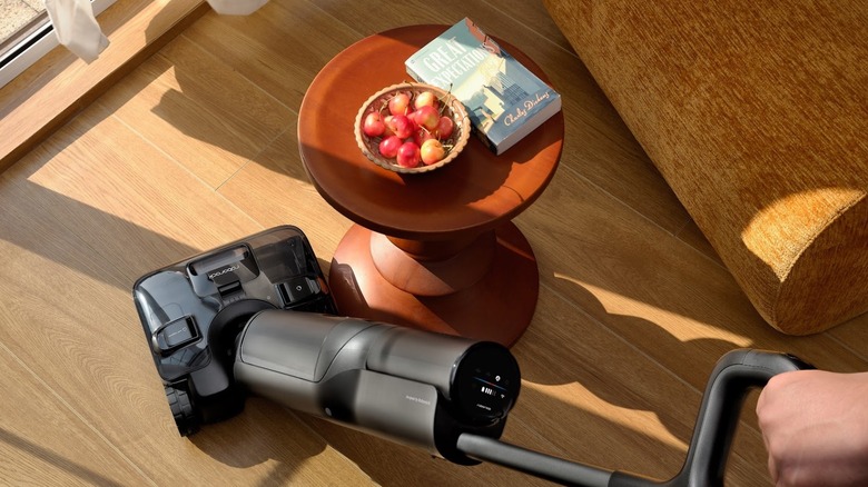 Person cleans a dirty room with Roborock F25 Ace Pro stick vacuum