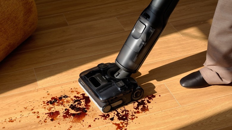 Person cleans a dirty room with Roborock F25 Ace Pro stick vacuum