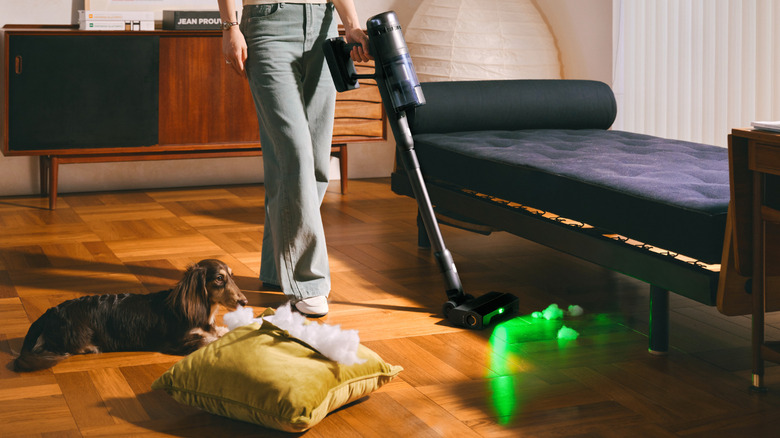 A woman cleaning a house with the Roborock H60 Ultra stick vacuum