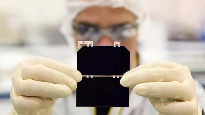 A Rocket Lab employee seen holding a set of solar cells.