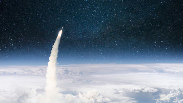 A rocket punching through the clouds reaching into space