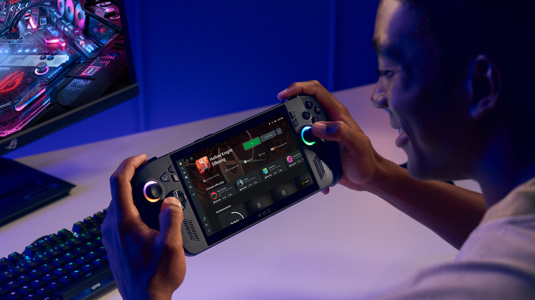 Someone playing a ROG Xbox Ally X in front of a desktop computer