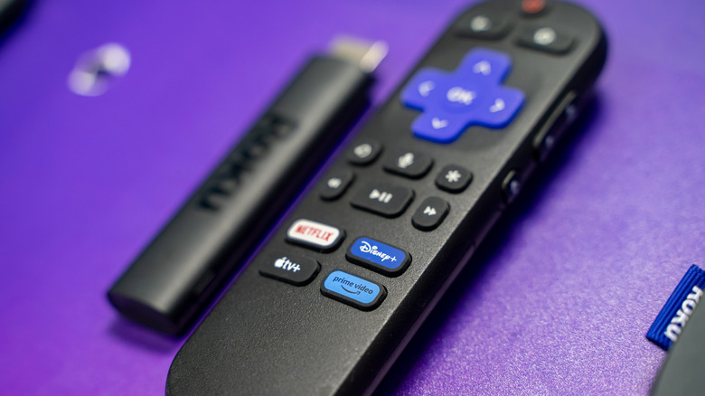 Roku remote next to a Roku device on a purple table
