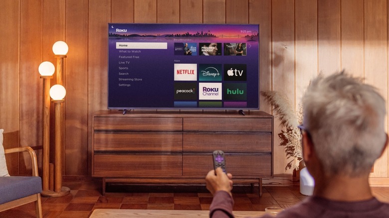 A man scrolling the new Roku software experience on TV