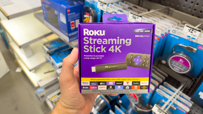A person holding the Roku Streaming Stick 4K box in a store