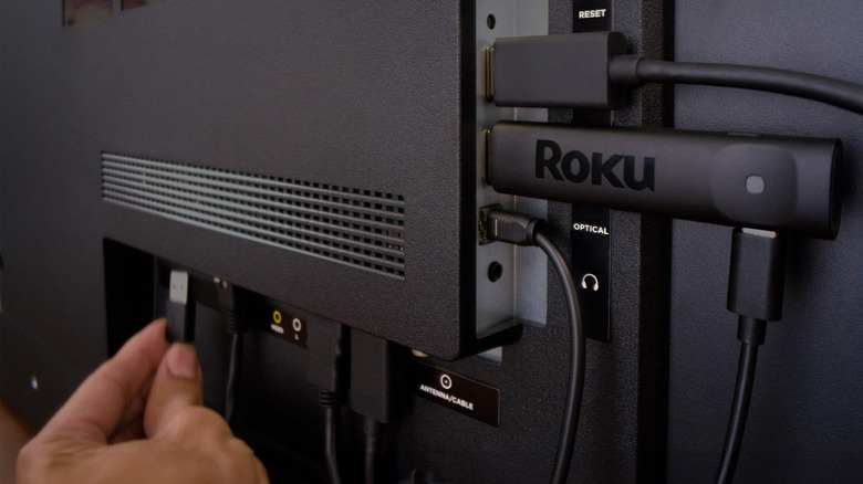A person connecting a USB cable to power Roku Streaming Stick Plus