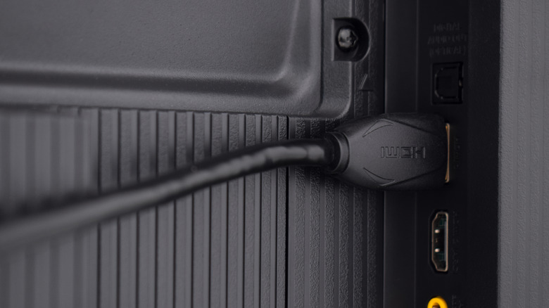 close-up of HDMI cable plugged into a slightly recessed port area on the back of a TV