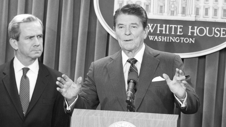 President Ronald Reagan announces the resignation of national security adviser Robert McFarlane standing beside him.
