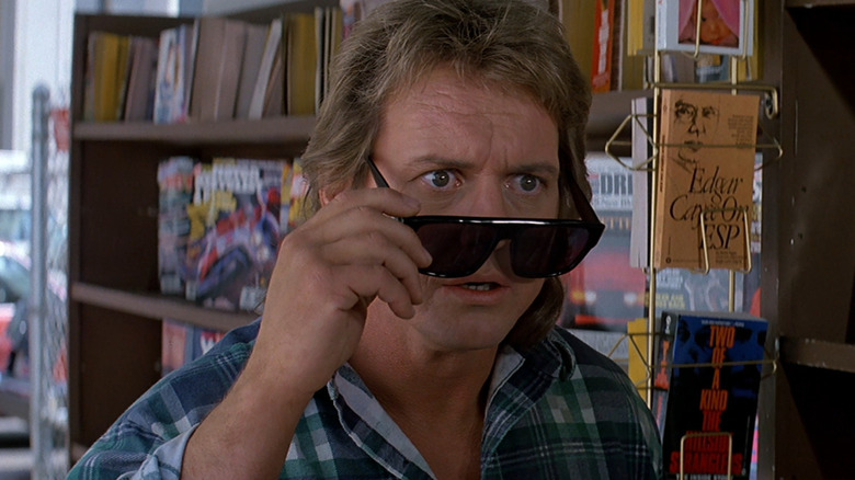 Neda (Roddy Piper) lowering his sunglasses in 