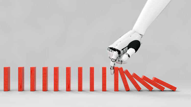 Humanoid robot arm knocking over dominos.
