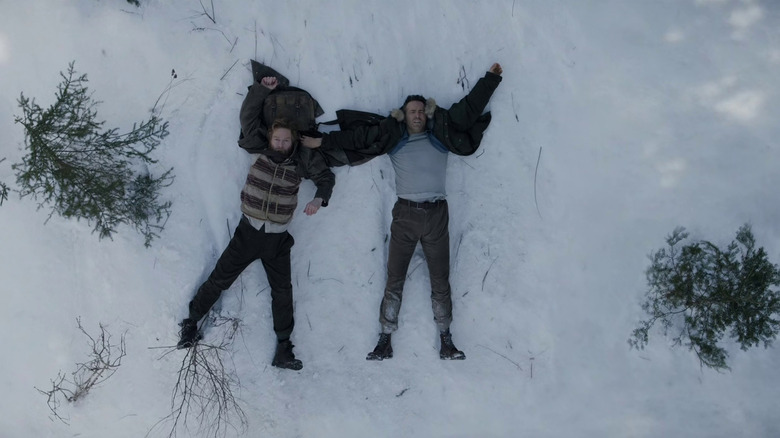 Nik and Troy lying on their back in the snow