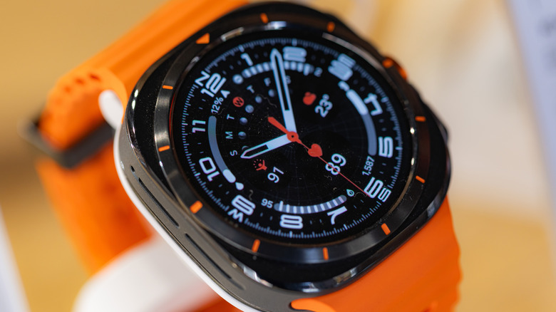A closeup of the watch face on a Samsung Galaxy Watch Ultra with an orange band
