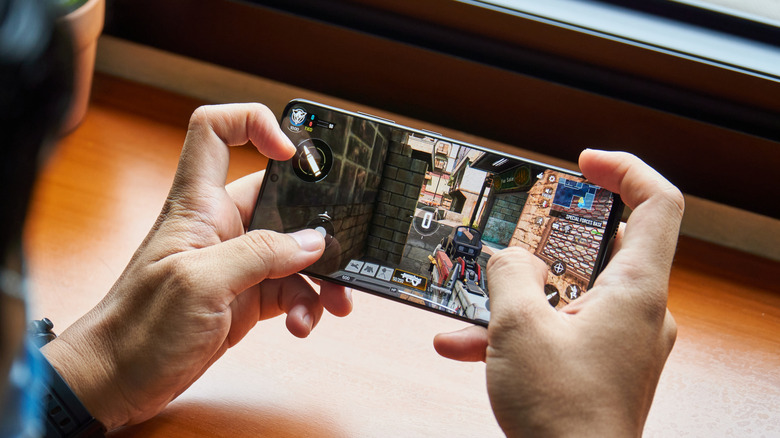 A person playing "Call of Duty: Mobile" on a Samsung Galaxy S21.