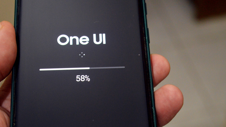 fingers holding a smartphone updating samsung one ui