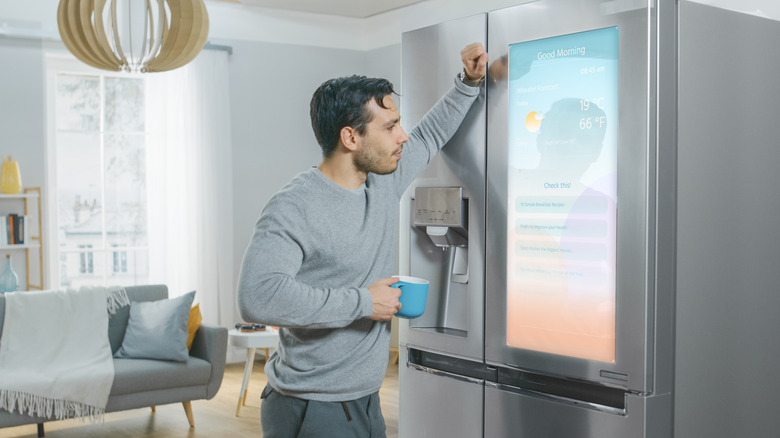 man staring at screen on smart fridge concept