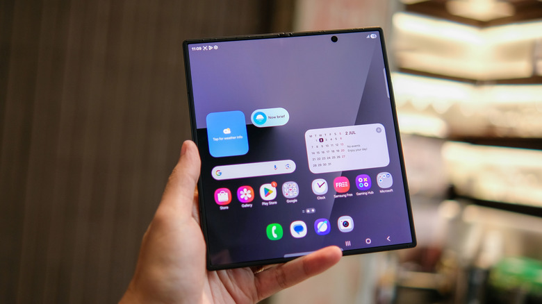 Hand holding Samsung foldable phone.