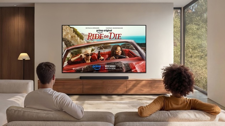 A couple looking at key art for the series Ride or Die on Prime