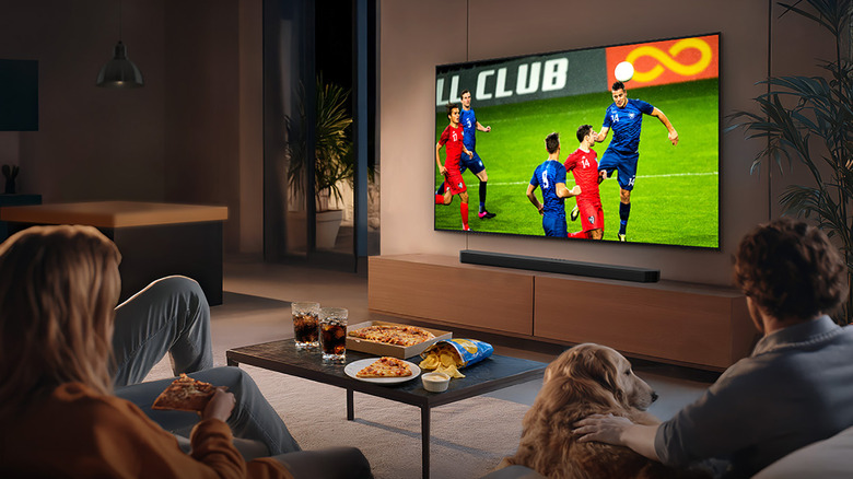 A family and a dog watching soccer on the Samsung QN80H TV