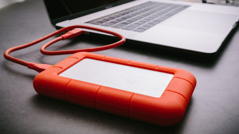 Close up of a rugged hard drive next to a laptop