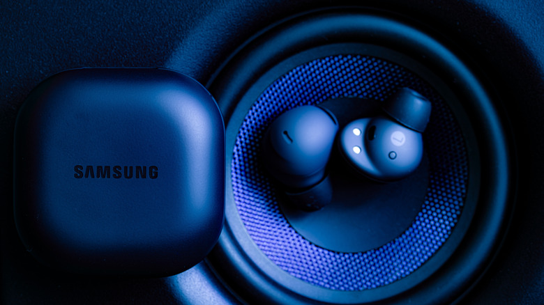 samsung galaxy buds resting on top of a speaker