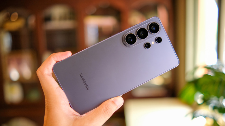 A person holding a Samsung Galaxy S26 Ultra in their hand at a tilted angle