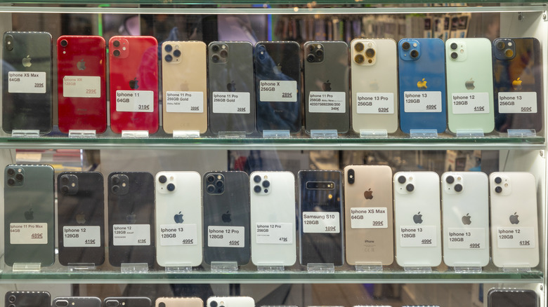 A number of smartphone from different brands being showcased in a glass shelf