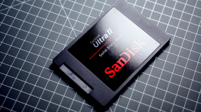 Sandisk SSD visible on grid surface with dim lighting.