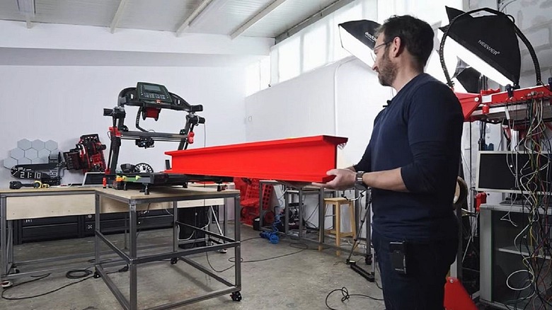 Ivan Miranda supporting plastic girder printed from treadmill 3d printer