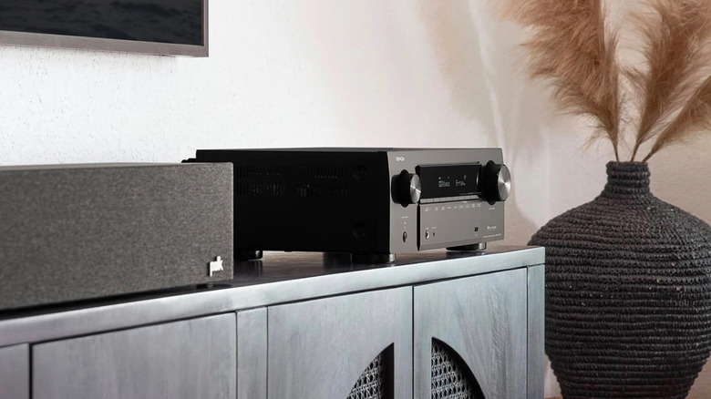 A side angle of the Denon AVR-X7100H AV Receiver on a stand.