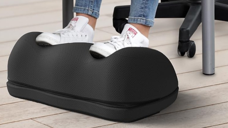 A desk worker using the Everlasting Comfort foot rest.