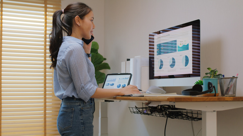 A worker at an adjustable standing desk.