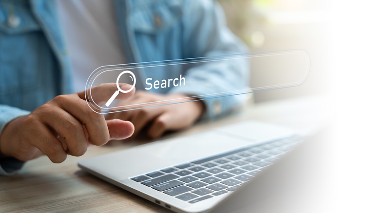 person pointing to a virtual image of a search bar