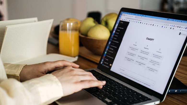 person typing to chatgpt on a laptop