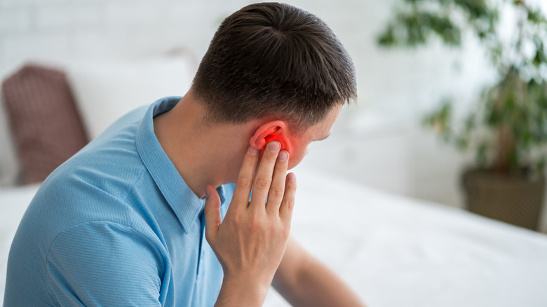 a man holding his ear in pain