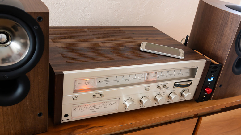 A smartphone placed on top of a vintage stereo.