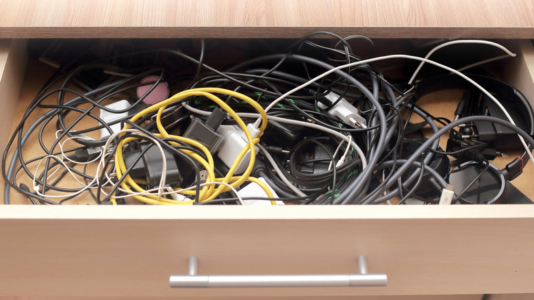 a messy drawer full of battery charging cables