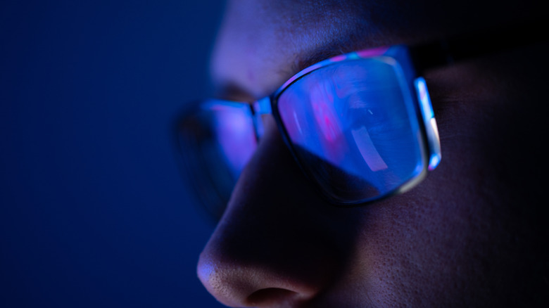 a close up of a face wearing blue light glasses