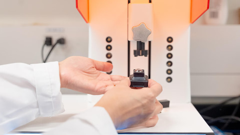 pair of hands holding a 3D printed contact lens