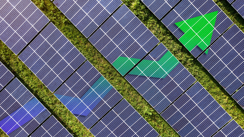 An upward line graph arrow drawn across a series of solar panel arrays
