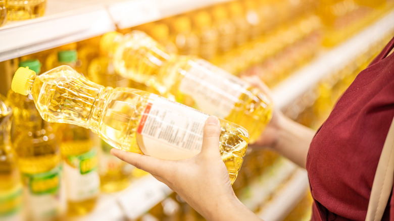 a person buying cooking oils from a grocery store