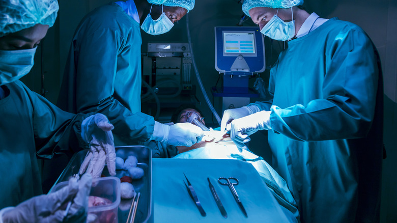 Surgeons and team conducting surgery on a patient in an operating room.